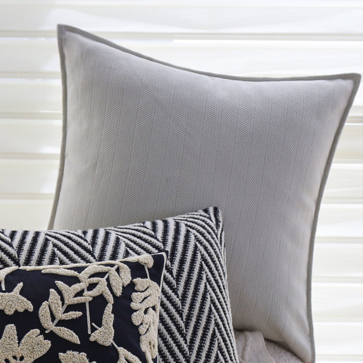 Square cushion cover with subtle herringbone texture and surrounding piping seam Kalsten