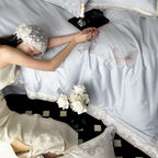 Satin bedding set with embroidered butterfly motif and silk-matte finish